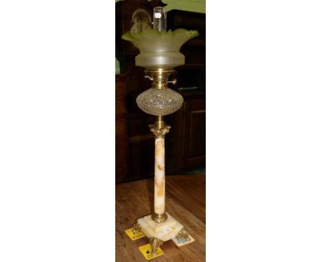 A brass and onyx Corinthian column oil lamp, with green tinted and etched shade, clear glass reservoir, lion mask and claw fe