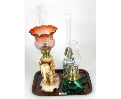 A continental elephant form ceramic oil lamp, blush ground, etched shade, 32cm high; A Chinese blue and white vase lamp; and 
