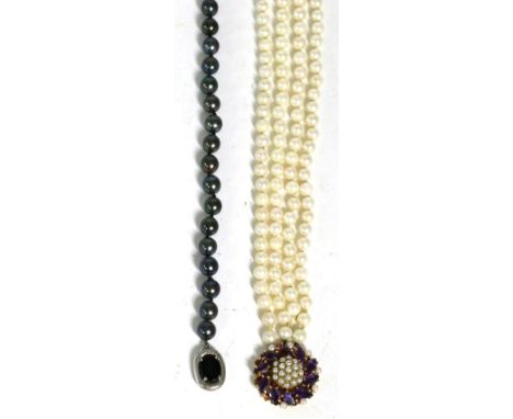A black cultured pearl necklace, uniform cultured pearls knotted to an onxy set clasp, stamped '9CT', length 48cm and a four 