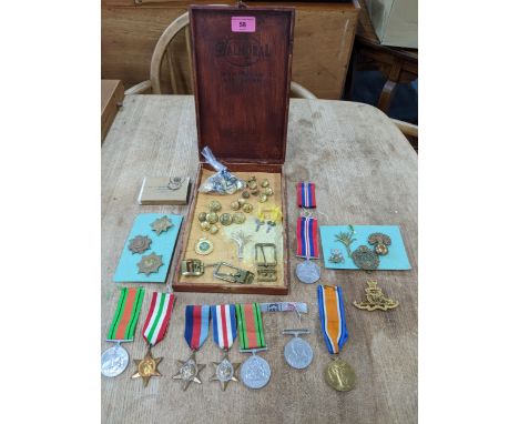 A group of WWI and WWII campaign medals, cap badges, buttons, buckles and other items to include a Victory medal named to 182