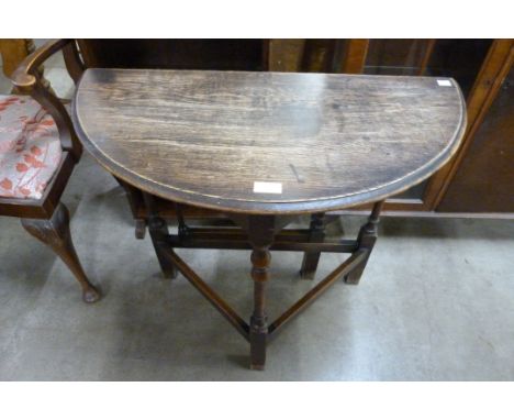 An oak drop-leaf demi lune hall table 