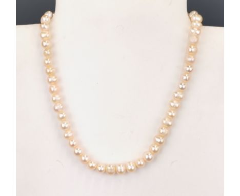 A single strand cultured cream pearl necklace on a white metal (tested silver) clasp, L. 36cm, approx. Dia. 0.7cm.