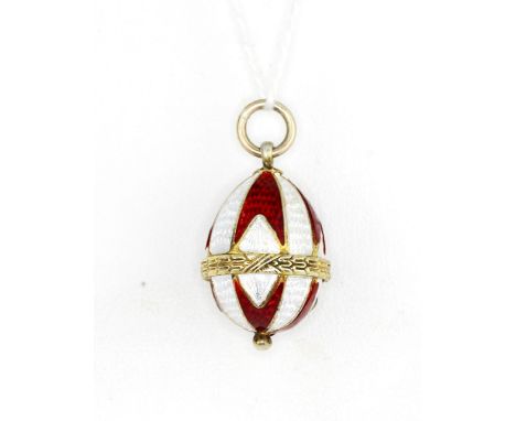 A yellow metal (tested minimum 9ct gold) red and white enamel Faberge egg style pendant, approx. L. 2.5cm.