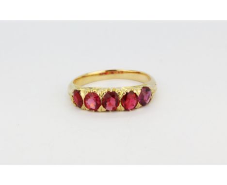 A yellow metal (tested minimum 9ct gold) ruby set five stone ring, (L).