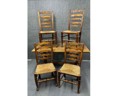 A 1920's oak refectory table with four ladder back rush seated chairs, L. 150 x 75cm.