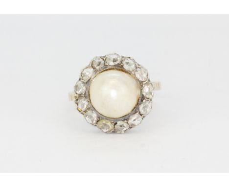 An antique yellow metal (tested minimum 9ct gold) set with a large cultured pearl surrounded by rose cut diamonds, (O.5).
