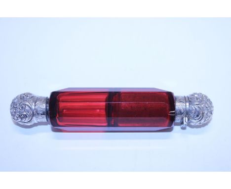 A double ended ruby glass scent bottle with white metal tops 