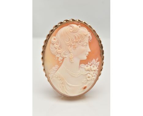 A 9CT GOLD CAMEO BROOCH, large oval brooch, carved shell cameo depicting a lady in profile, collet set with a rope twist surr