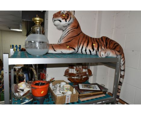 A LARGE TIGER SOFT TOY, brass oil lamp, basket of shells, framed prints, W.H. Goss Crested ware, a wooden model ship, etc. (s