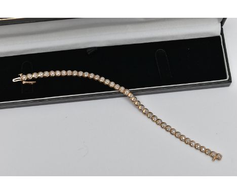 A 9CT GOLD DIAMOND LINE BRACELET, designed as a series of circular links each set with a small round brilliant cut diamond, s