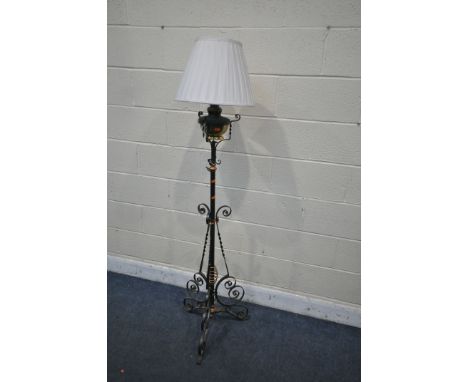 AN ARTS AND CRAFTS WROUGHT IRON, BRASS AND COPPER CONVERTED OIL LAMP, fitted with an electrical fitting, fabric shade, along 