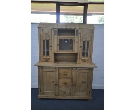 A VICTORIAN PINE CONTINENTAL DRESSER, the top with an arrangement of glazed cupboard doors, over a base with brushing slides,