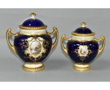 TWO EARLY 20TH CENTURY COALPORT TWIN HANDLED VASES AND COVERS, blue, pale yellow and gilt ground, the larger hand painted wit