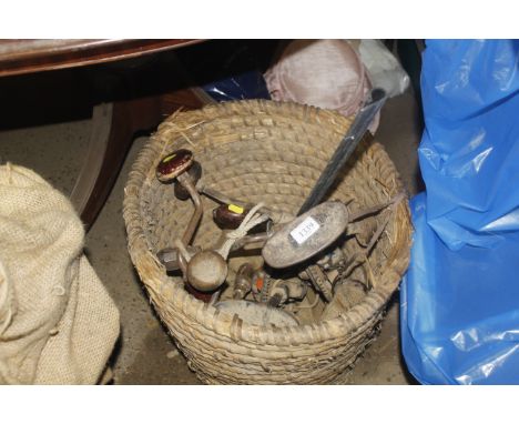 A wicker basket containing various vintage drill braces etc.