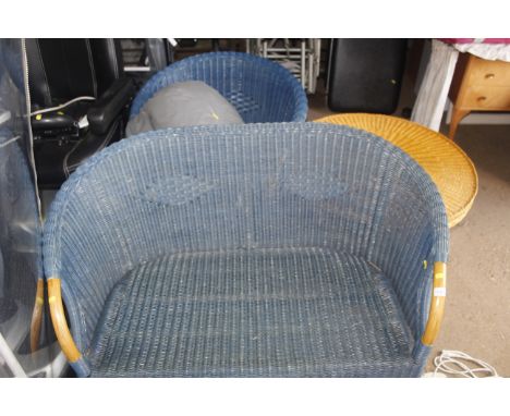 A blue wicker two seater sofa together with a blue wicker chair and yellow wicker side table