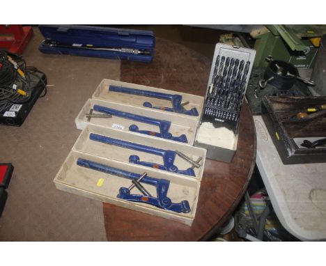 A cased Dormer drill bit set and four bench Holdfast clamps 