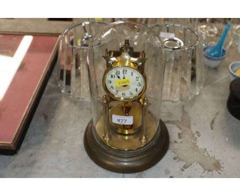 A brass anniversary clock under glass dome