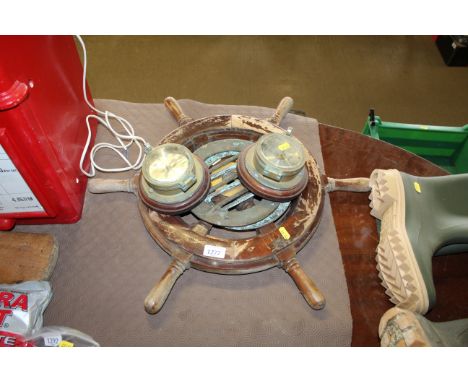 A wooden ships wheel; a barometer clock and two port hole grills