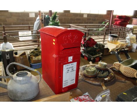 A red painted post box with internal light fitting