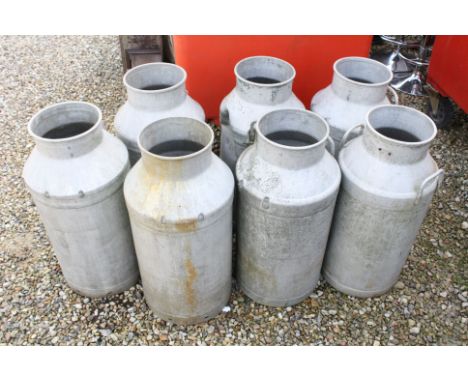 Seven vintage aluminium milk churns no lids.