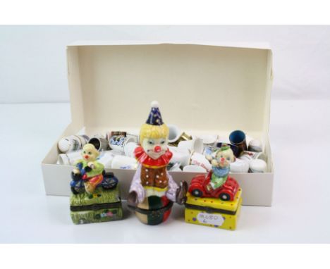 A collection of ceramic thimbles together with three ceramic clown trinket boxes