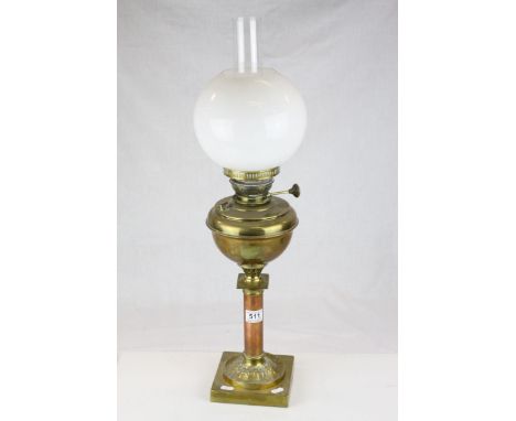 A brass and copper  oil lamp of corinthum form with shade and chimney..