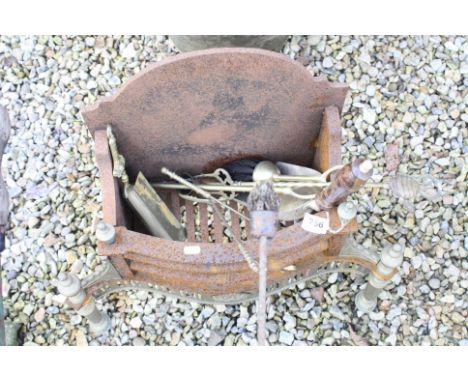A cast iron fire basket with tools.