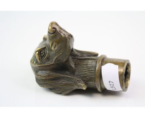 A brass/bronze walking stick handle in the form of a dog.