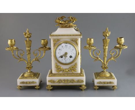 An early 20th century French ormolu and white marble clock garniture, the architectural cased clock surmounted with military 