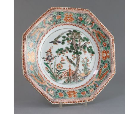 A Chinese famille verte octagonal dish, Kangxi period, painted with two courting birds in a garden with pine tree, flowers an