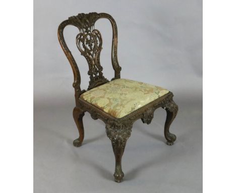 A George III Irish mahogany dining chair, with elaborate flower and scroll carved and pierced splat, floral tapestry drop-in 
