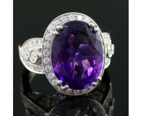 A modern 18k white gold, amethyst and diamond set dress ring, with diamond set shoulders and setting, size N.