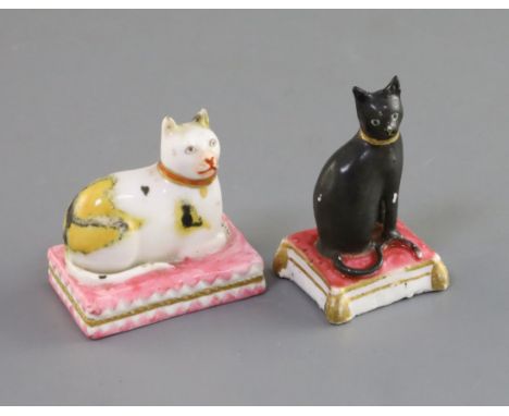 Two Derby porcelain figures of cats, c.1810-30, the first a black cat seated on a pink tasselled cushion, the model attribute