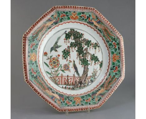 A large Chinese famille verte octagonal dish, Kangxi period, painted with two courting birds in a garden with pine tree, flow