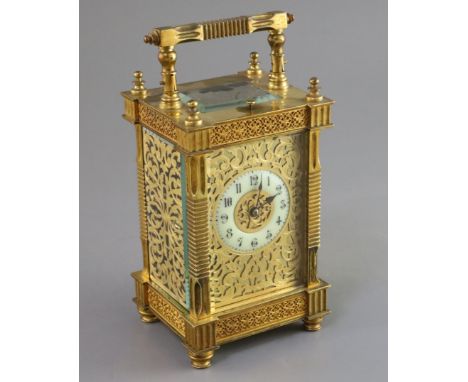 An early 20th century French ormolu hour repeating carriage clock, in ornate scrollwork case with blind fretwork panels and a