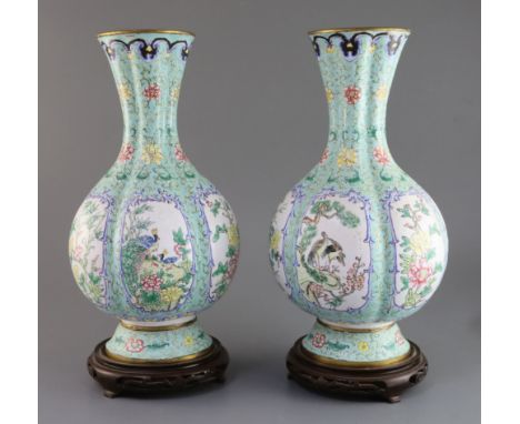 A pair of Chinese Canton enamel vases, early 20th century, each painted with birds and flower reserves on a pale green floral