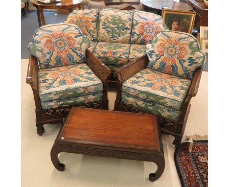 A 1920s Bergere suite comprising two armchairs and a sofa with gilt highlights to the carved arms with loose cushions in an o