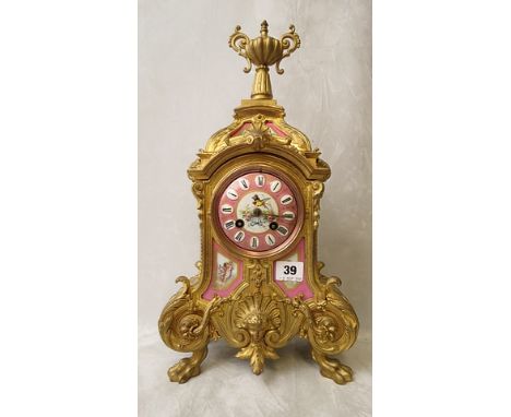 A 19th century French gilt mantle clock having ornate cast decoration with pink glazed foliate porcelain plaques and dial, 18
