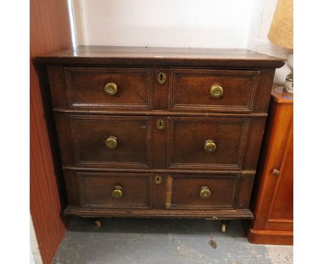 An 18th century provincial oak Jacobean style chest of three long drawers with panel prints on later legs