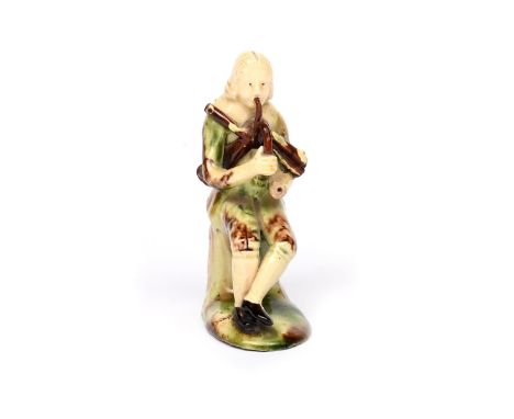 A Staffordshire creamware figure of a musician  mid 18th century, of Astbury-Whieldon type, seated and playing the bagpipes, 