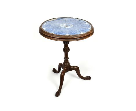 A George III table with delftware top, set with a London delftware circular plaque or tray painted in blue with a lotus desig