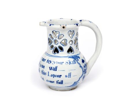A Liverpool delftware puzzle jug  c.1740-60, the squat body inscribed with a four line wager inviting the drinker to 'come tr