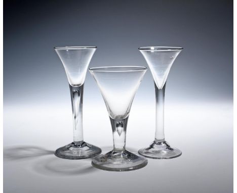 Three wine glasses  c.1750-60, with drawn trumpet bowls over plain stems, two enclosing long tears, the last over a domed foo