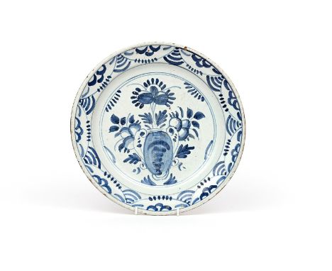 A London delftware dish  c.1640-60, painted in blue with a stylized vase of flowers, the rim with a simple panelled design, t