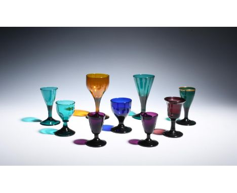 Nine coloured glass wine and dram glasses  late 18th/early 19th century, including an amber cup bowl, four green trumpet and 