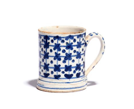 A small delftware mug  c.1740, the cylindrical form decorated in blue with a chequered design including dots and crosses, the