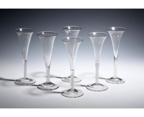 Six wine flutes  c.1760, the slender drawn trumpet bowls with slightly everted rims, rising from double series opaque twist s