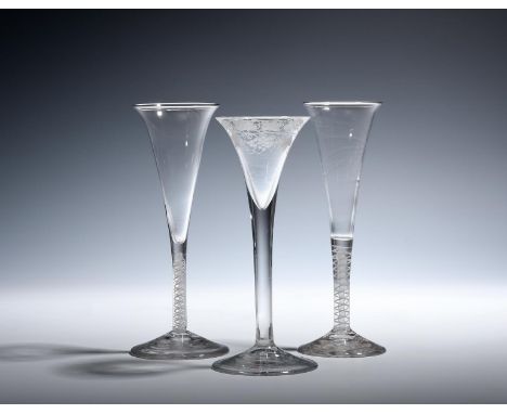 Two wine flutes  c.1760, the slender drawn trumpet bowls with everted rims, raised on double series opaque twist stems, and a