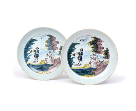 A pair of London delftware saucer dishes  c.1765, painted in blue, green, yellow and manganese with a lady beckoning to a gen