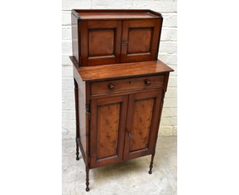 An early to mid-19th century mahogany side cabinet of small proportions, with two panelled doors above a drawer and two cupbo